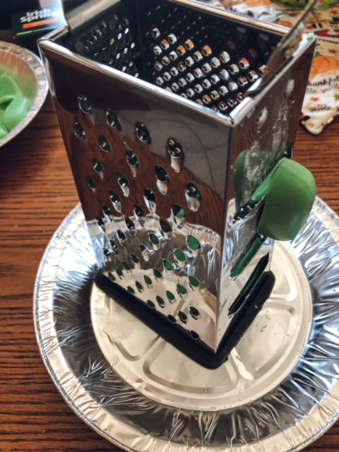 Using a cheese grater to slice the Irish Spring soap.